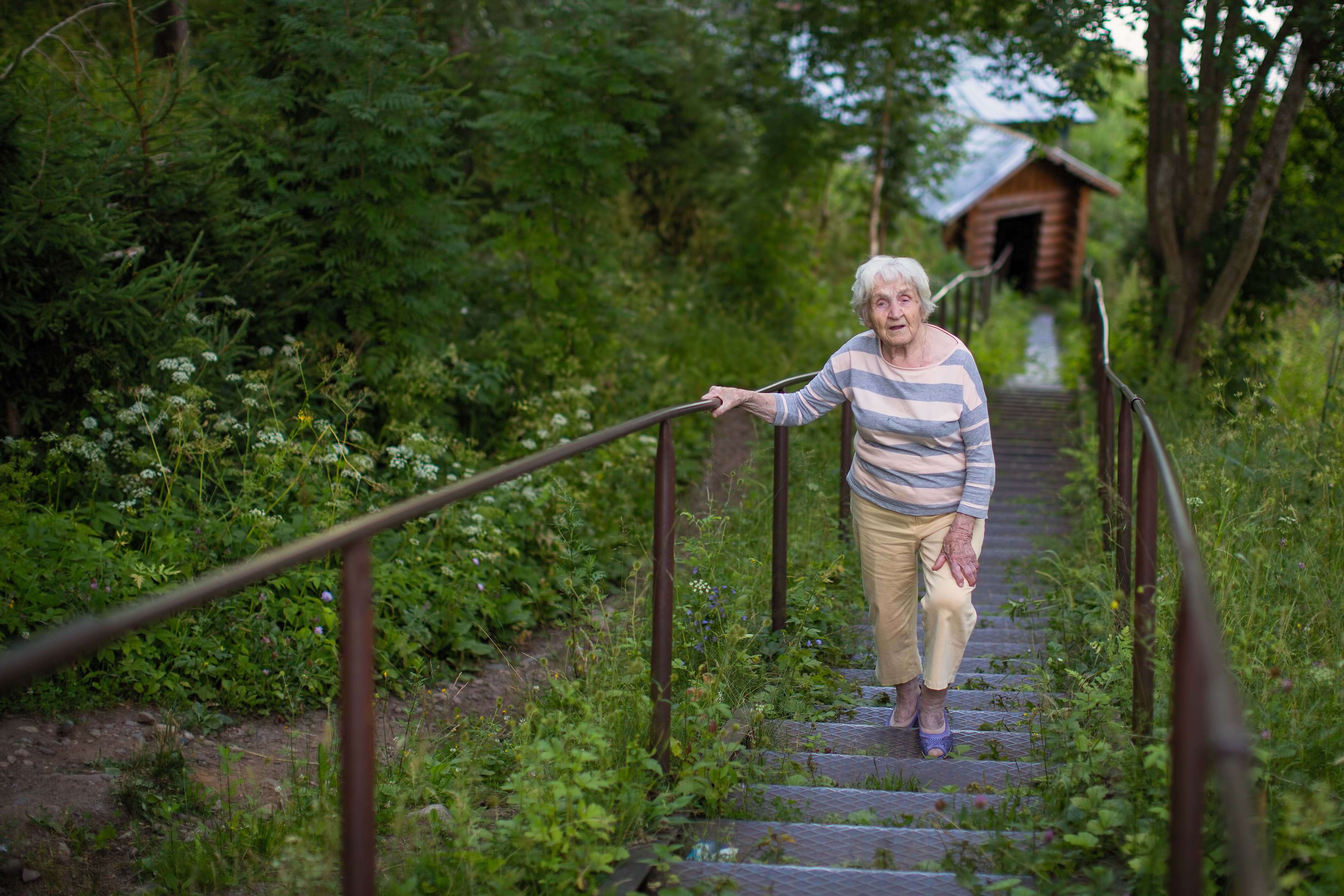 Illustrasjonsbilde en eldre kvinne som går opp en lang trapp