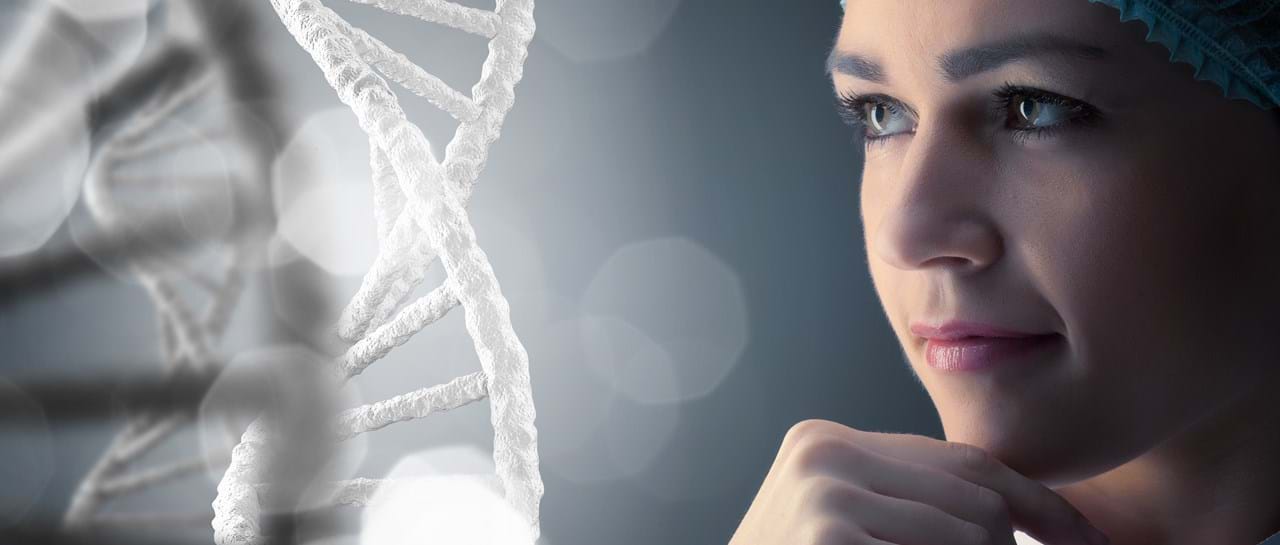 Nærbilde av en kvinne i medisinsk hodeplagg som ser tankefullt mot en stor, hvit DNA-dobbelheliks i forgrunnen. Bakgrunnen er diffus og gir et vitenskapelig og moderne inntrykk